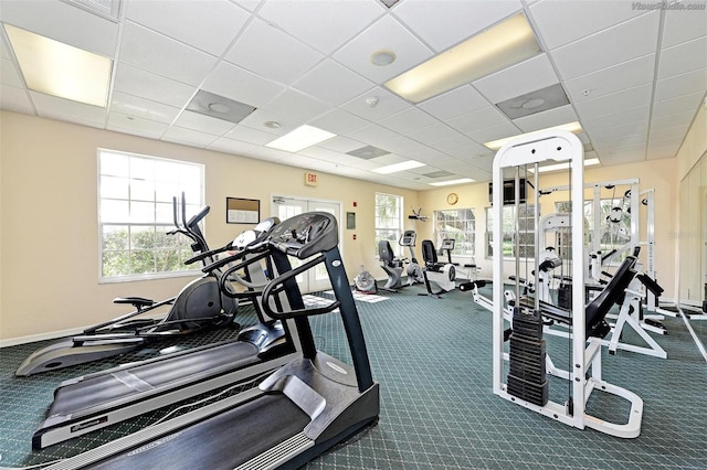 exercise room with a drop ceiling and dark carpet