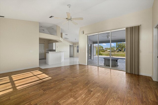 unfurnished living room with ceiling fan, wood-type flooring, and lofted ceiling