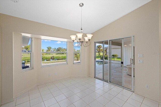 unfurnished dining area featuring light tile patterned floors, a chandelier, and vaulted ceiling