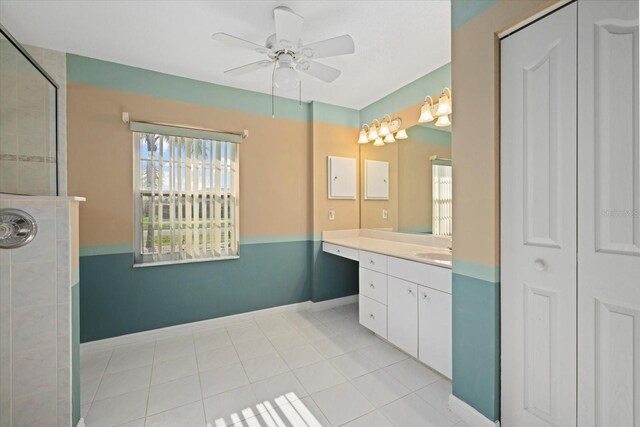 bathroom with a tile shower, vanity, tile patterned floors, and ceiling fan