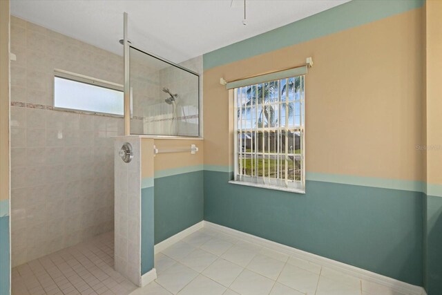 bathroom featuring tiled shower and tile patterned flooring