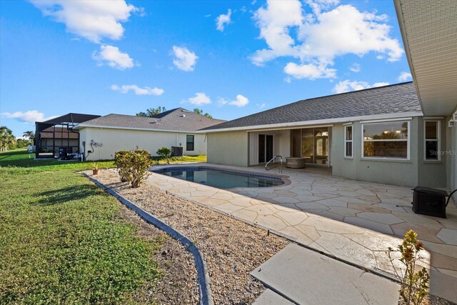 view of pool with a lanai, a lawn, and a patio