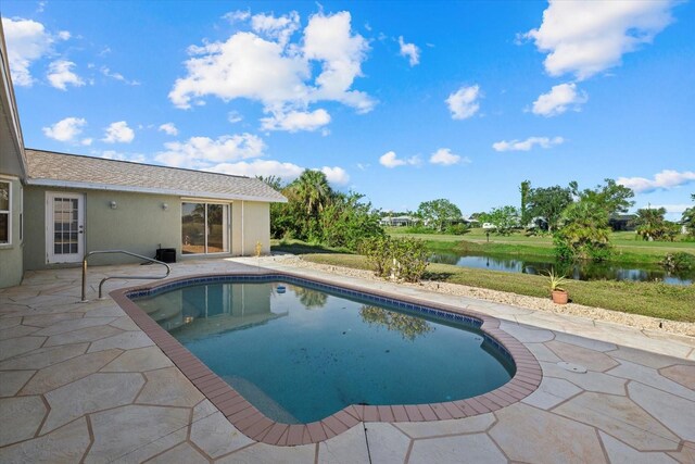 view of swimming pool with a water view and a patio