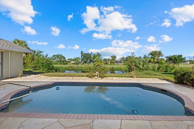 view of pool with a patio and a water view