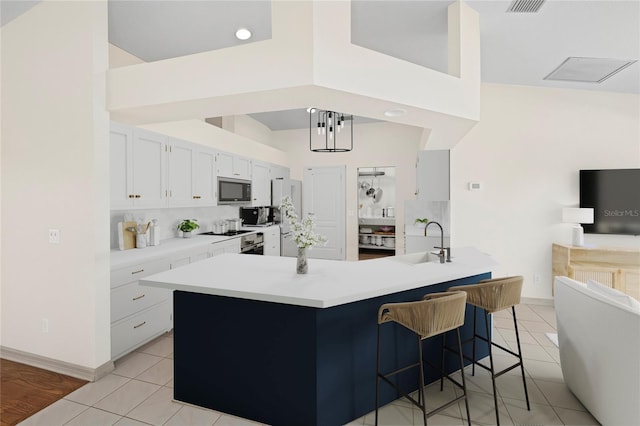 52 Fairway Rd, Rotonda West, FL 33947 - kitchen with stainless steel microwave, a breakfast bar, light tile patterned flooring, and backsplash