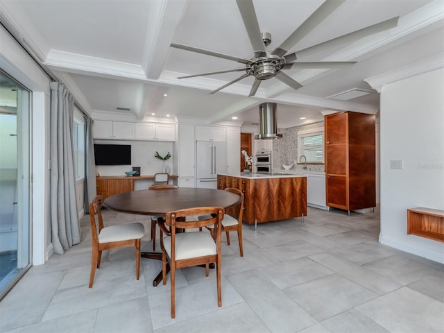 tiled dining space with coffered ceiling, ornamental molding, ceiling fan, sink, and beam ceiling