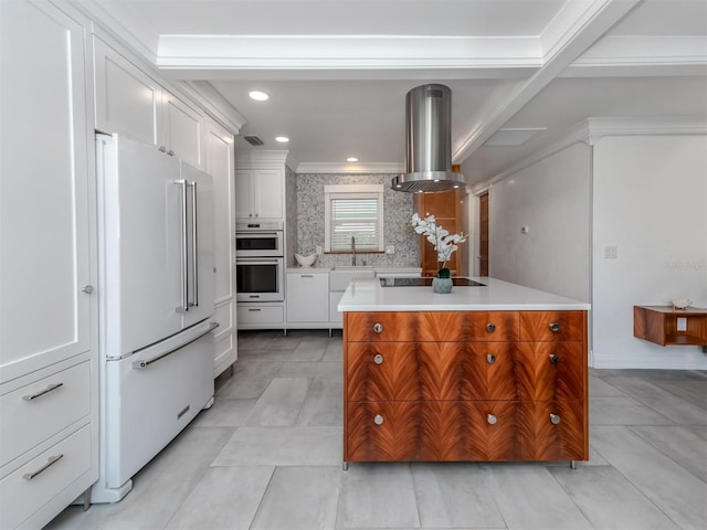 kitchen featuring white cabinets, island exhaust hood, high end white fridge, decorative backsplash, and a kitchen island