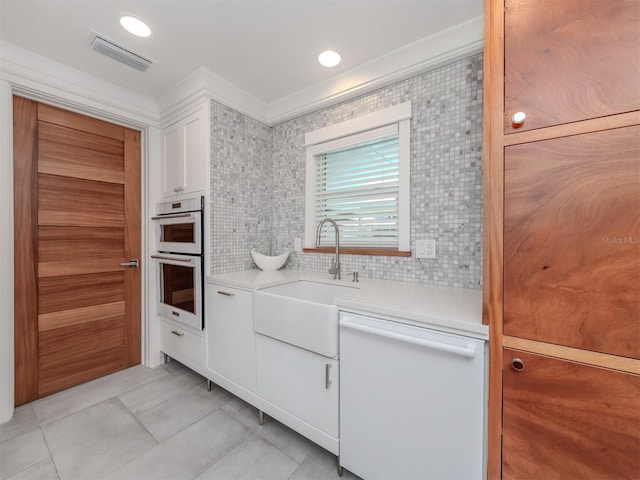 kitchen featuring dishwasher, backsplash, white cabinets, ornamental molding, and stainless steel double oven