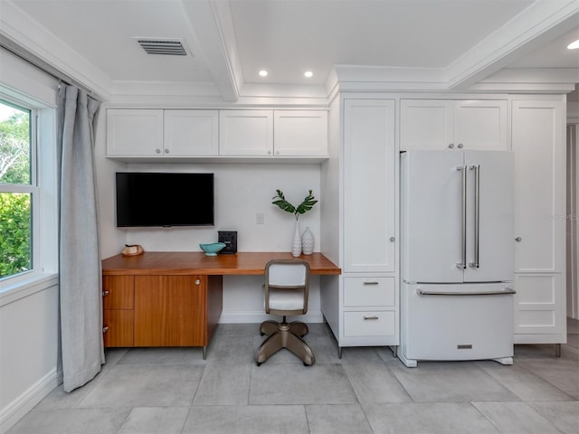 office area with beam ceiling, built in desk, and ornamental molding