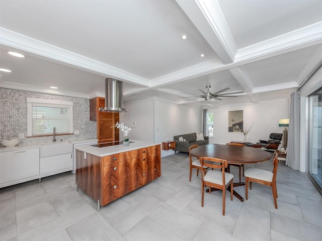 kitchen with a kitchen island, sink, wall chimney range hood, beamed ceiling, and white cabinetry