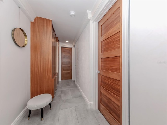 hallway featuring light tile patterned floors and ornamental molding