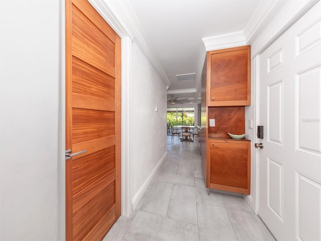 hall featuring light tile patterned flooring and ornamental molding