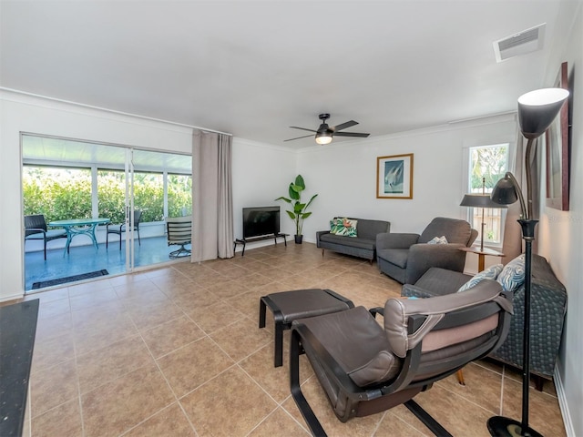 tiled living room with crown molding and ceiling fan