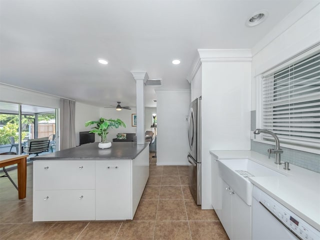 kitchen with stainless steel refrigerator, ceiling fan, sink, white dishwasher, and white cabinets