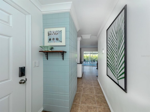 hallway with tile patterned floors and ornamental molding