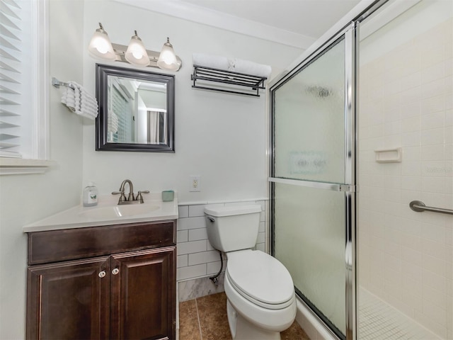 bathroom with toilet, vanity, tile patterned floors, and a shower with shower door