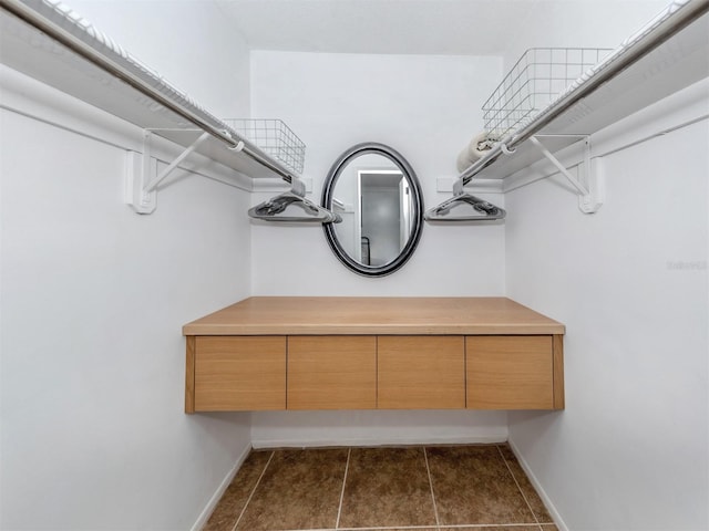 walk in closet featuring dark tile patterned floors