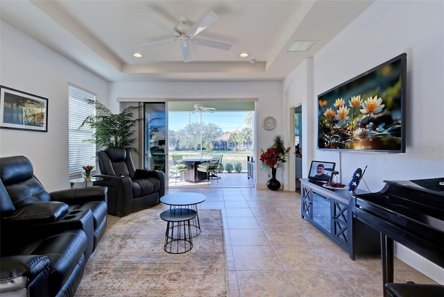 living room featuring a tray ceiling and light tile patterned floors