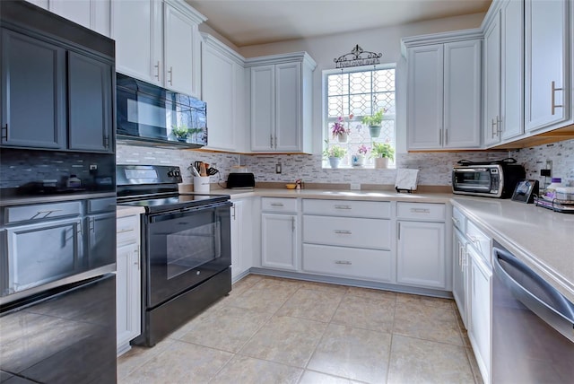 kitchen featuring light tile patterned floors, backsplash, white cabinetry, and black appliances