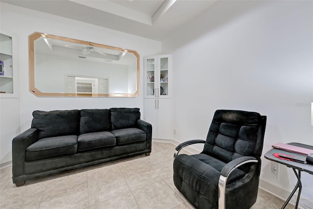 living room featuring light tile patterned floors, a tray ceiling, and ceiling fan