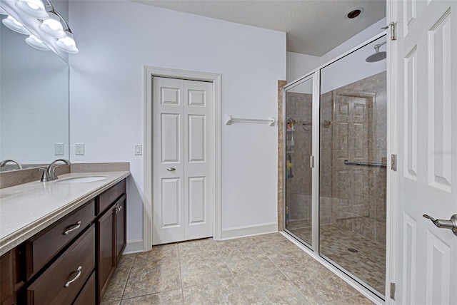 bathroom featuring a shower with door, vanity, and tile patterned flooring