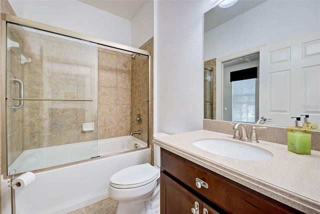 full bathroom featuring vanity, bath / shower combo with glass door, and toilet