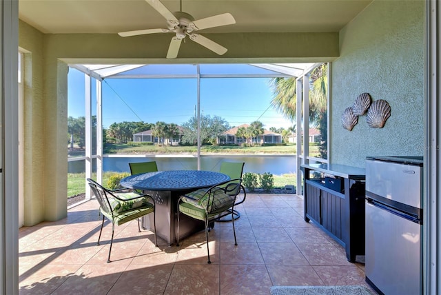 sunroom with a water view and ceiling fan