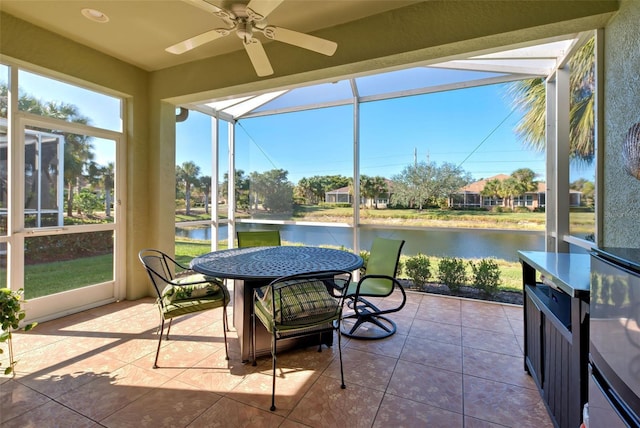 sunroom / solarium featuring a water view and ceiling fan