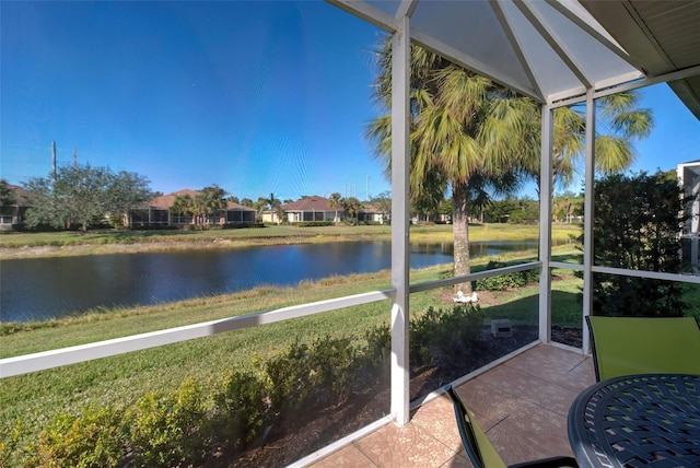 sunroom featuring a water view