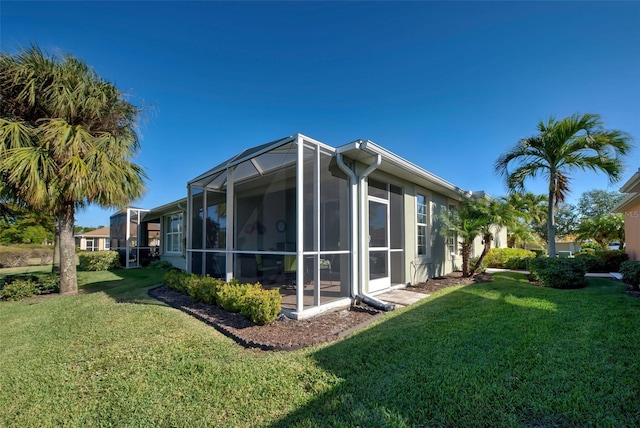 view of side of home featuring a yard and glass enclosure