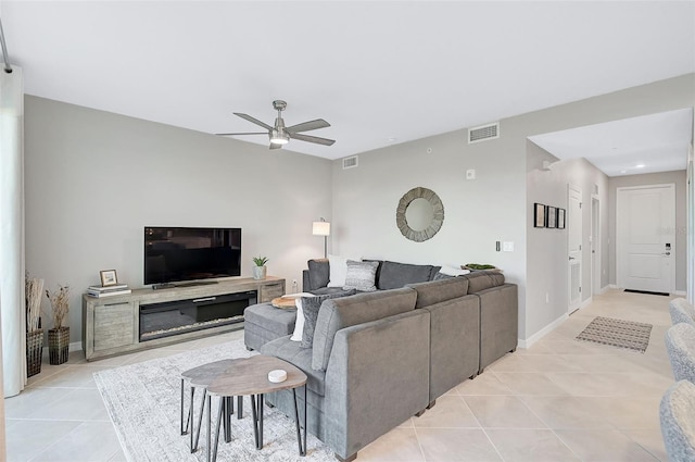 living area featuring visible vents, ceiling fan, baseboards, and light tile patterned flooring