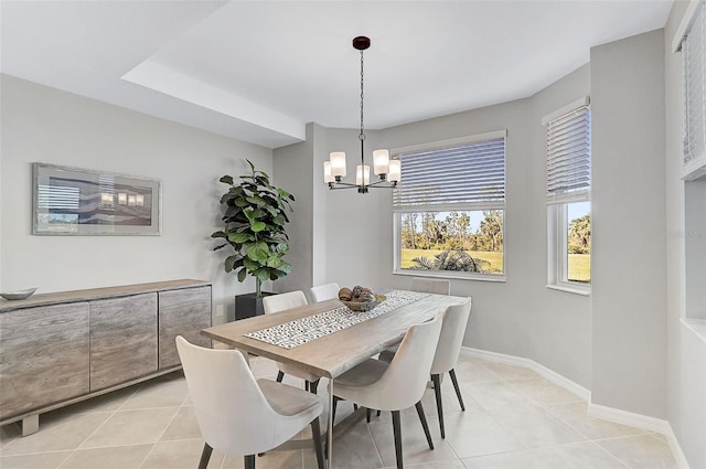 dining area with light tile patterned floors, an inviting chandelier, and baseboards