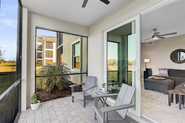 sunroom / solarium with a ceiling fan and visible vents