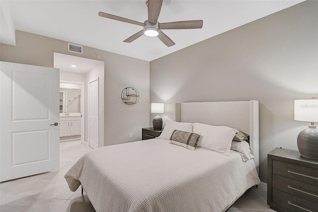 bedroom with light tile patterned floors, a ceiling fan, visible vents, and ensuite bathroom