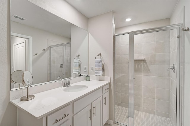 full bathroom with visible vents, vanity, and a shower stall