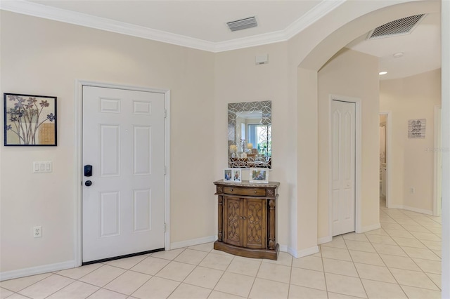 foyer entrance with light tile patterned flooring and ornamental molding