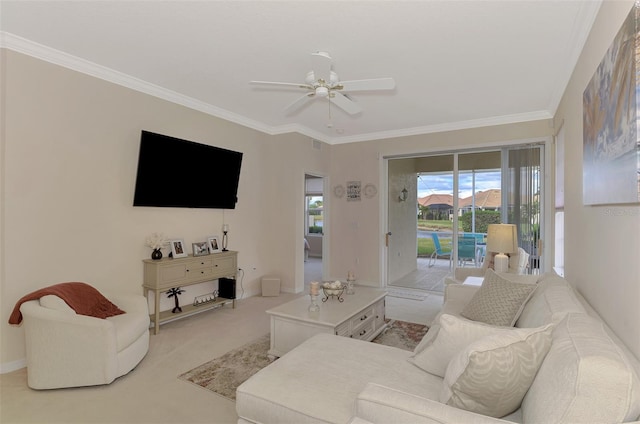 living room featuring ceiling fan, crown molding, and light carpet