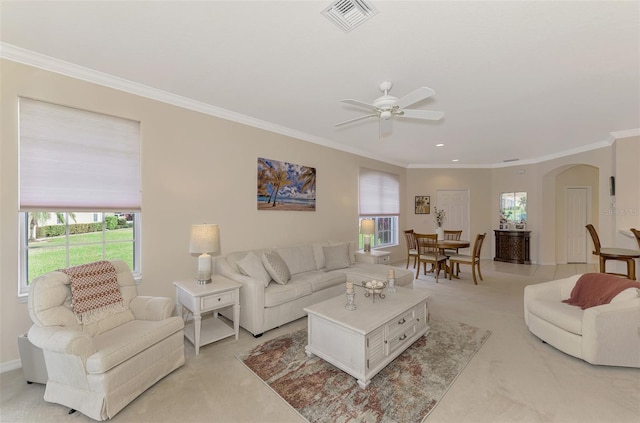 living room featuring ceiling fan, crown molding, and light carpet