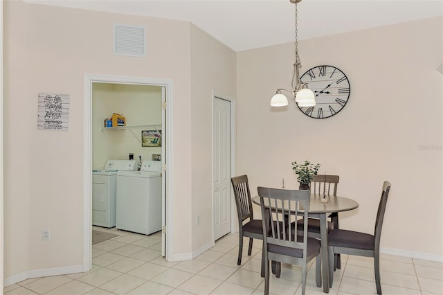 tiled dining room with a notable chandelier and independent washer and dryer