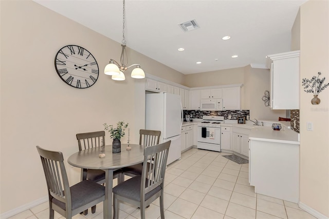 kitchen with a notable chandelier, white appliances, white cabinets, decorative backsplash, and decorative light fixtures