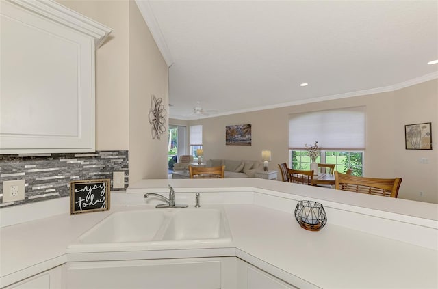 kitchen featuring white cabinets, crown molding, sink, decorative backsplash, and ceiling fan