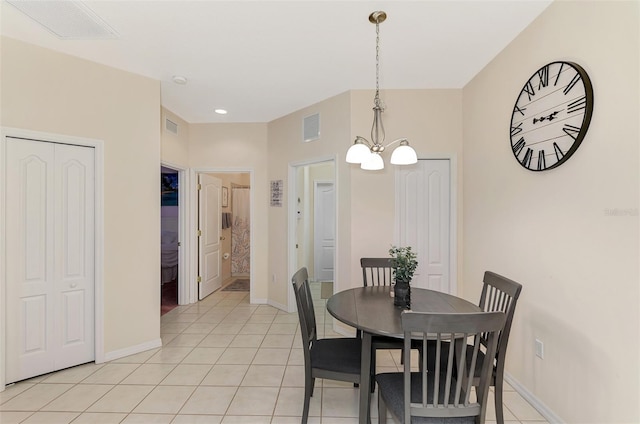 tiled dining space with an inviting chandelier