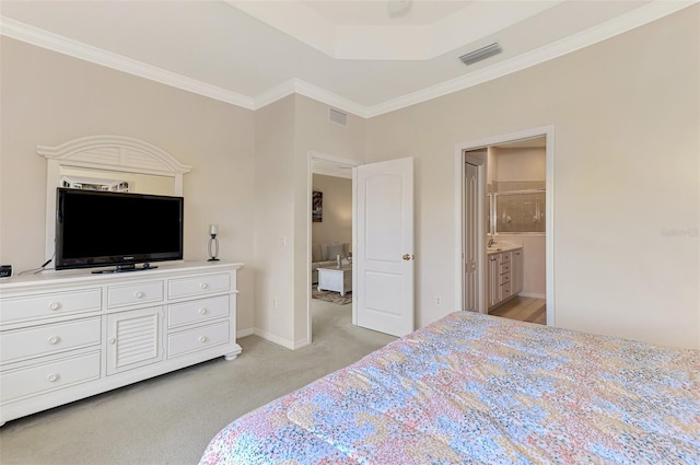 carpeted bedroom with crown molding and ensuite bath