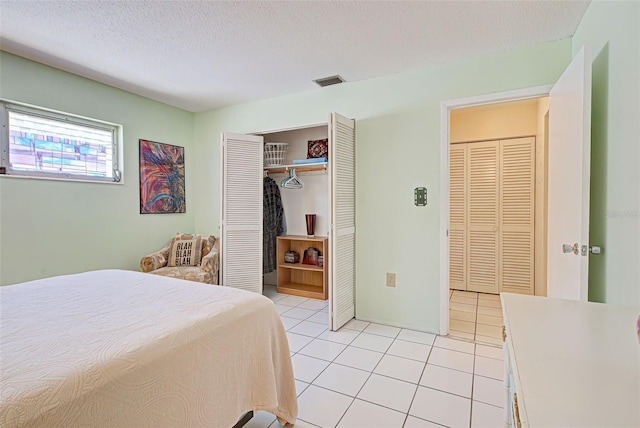 tiled bedroom featuring a closet and a textured ceiling