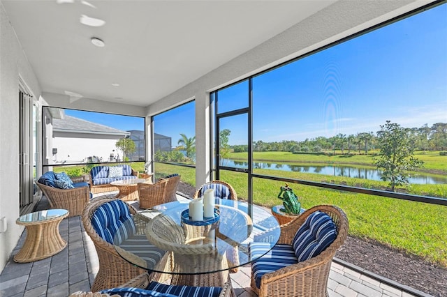 sunroom featuring a water view