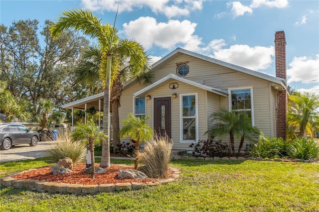 bungalow-style home with a front yard