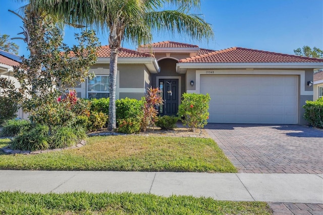 mediterranean / spanish-style home featuring a front yard and a garage