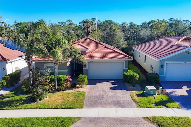 mediterranean / spanish home with a garage and a front lawn