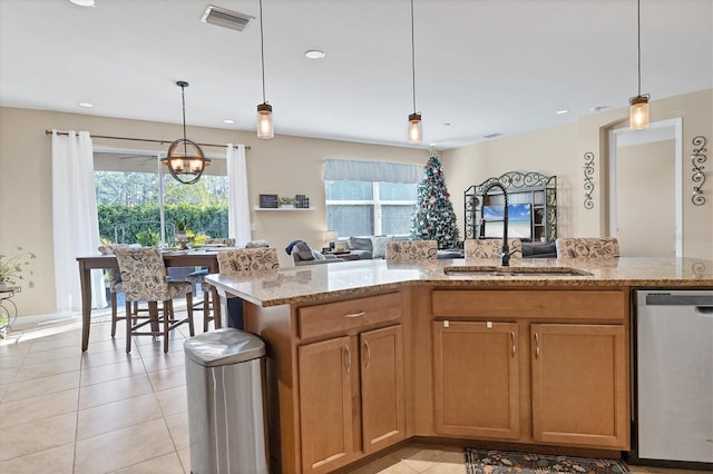 kitchen featuring stainless steel dishwasher, pendant lighting, and light stone countertops