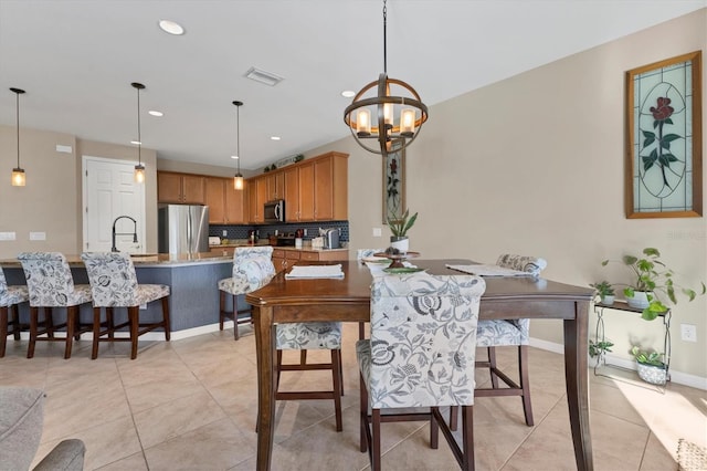 tiled dining room featuring sink and a notable chandelier